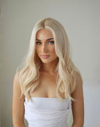 Front view of Pearle pearl blonde Remy human hair wig with a soft light brown root