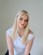 Model wearing Pearle glueless Remy human hair wig with soft waves and a polished blonde finish