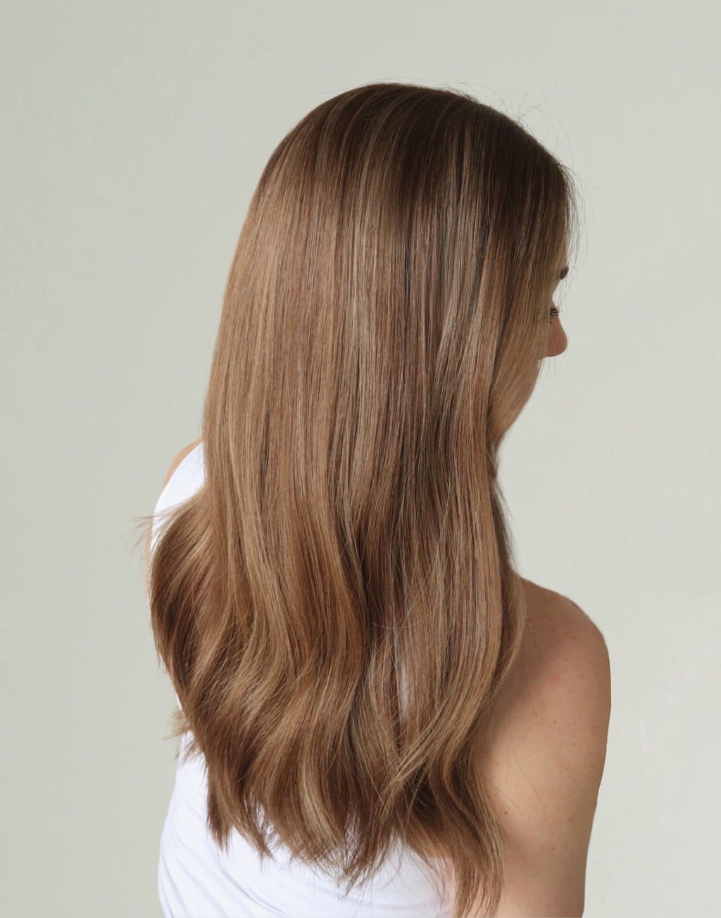 Three-quarter view of Amber 18-inch toasted almond brunette wig, showing warm brown highlights and softly blended dimensional color.