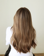 Back view of Amber 20-inch brunette human hair wig, featuring dimensional warm brown highlights and softly blended lighter lengths.