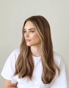 Side close-up of Amber 20-inch human hair wig, showing toasted almond brown color and softly blended highlights around the face.