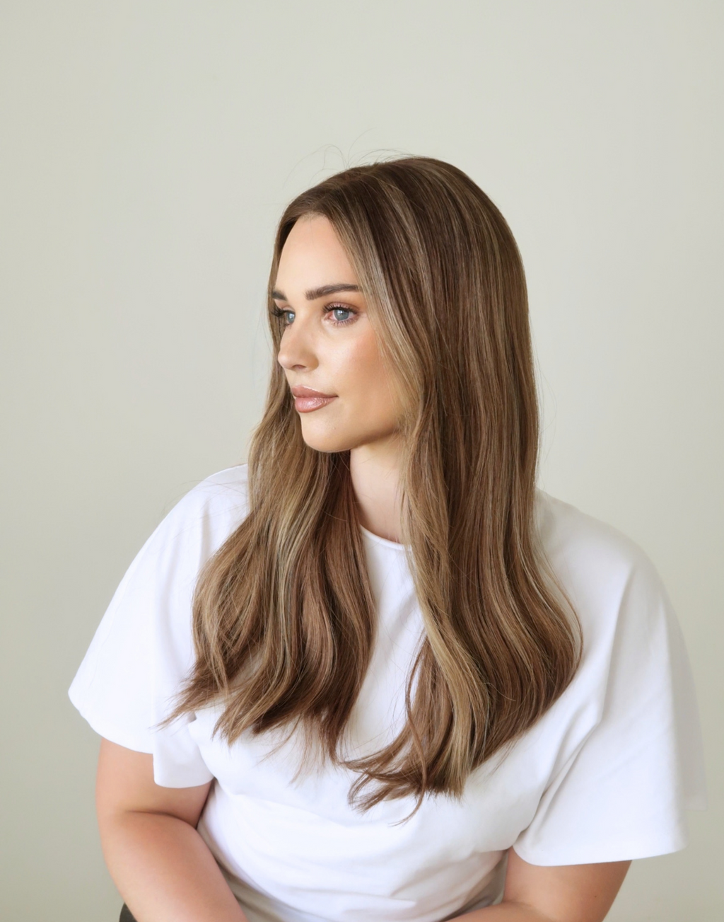 Three-quarter view of Amber 20-inch toasted almond brunette wig, highlighting the warm brown color and dimensional face-framing tones.