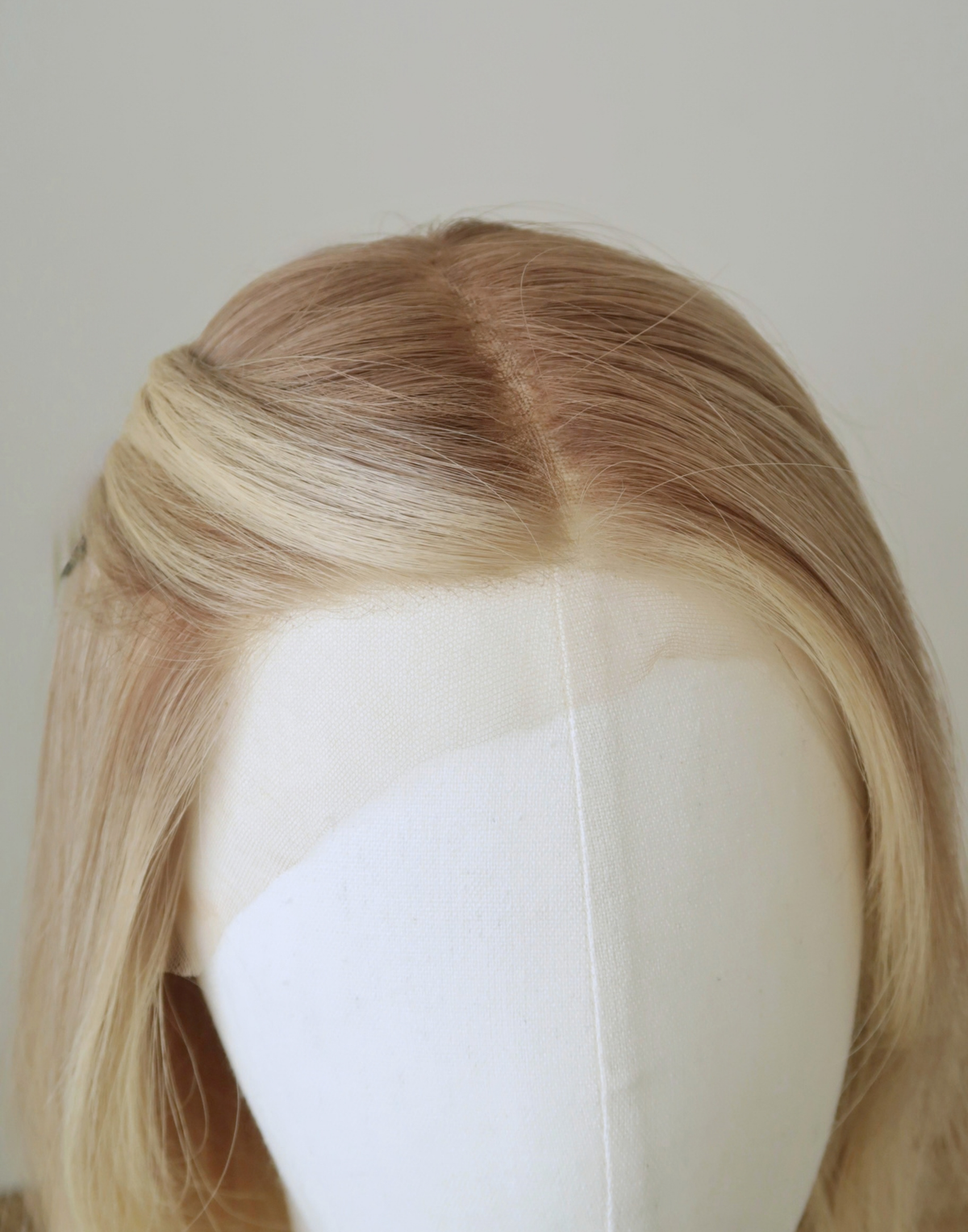 Close-up of Chantilly glueless Remy human hair wig showing the lace hairline, natural-looking parting, and soft blonde root shading.