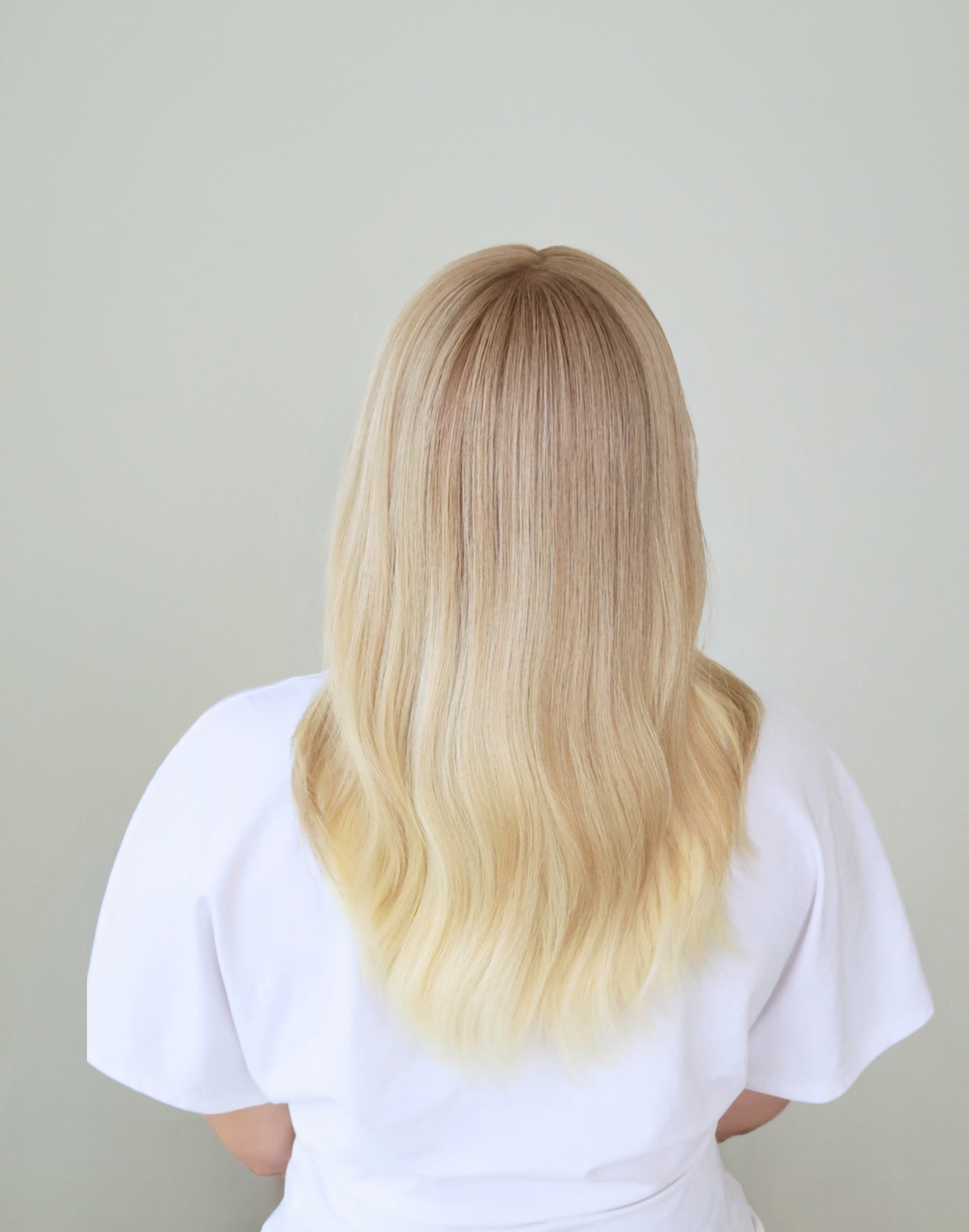 Back view of Chantilly vanilla blonde human hair wig, showing the transition from softly shaded roots to lighter blonde lengths.