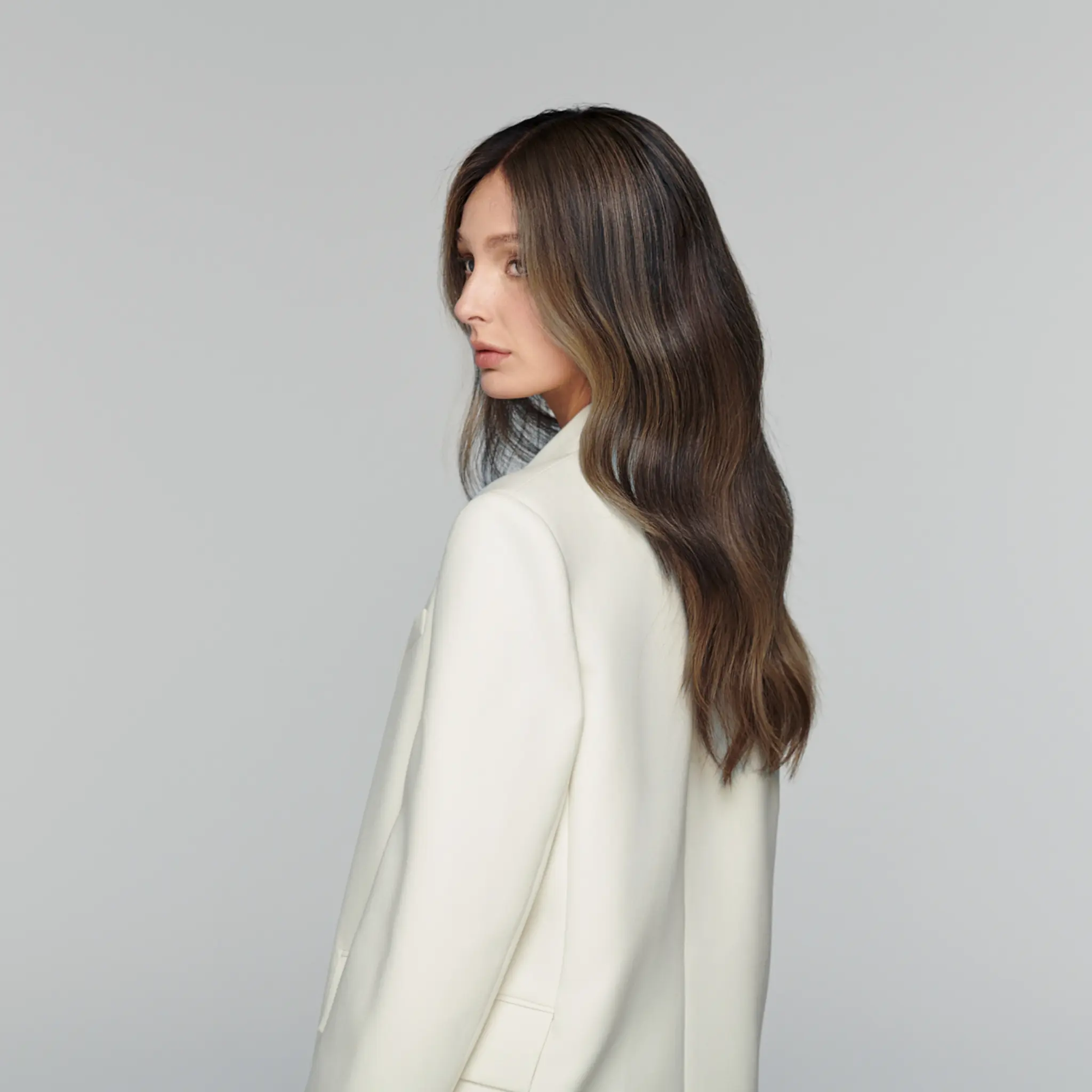 Model wearing dark caramel highlight brunette human hair wig with glueless lace front for effortless wear