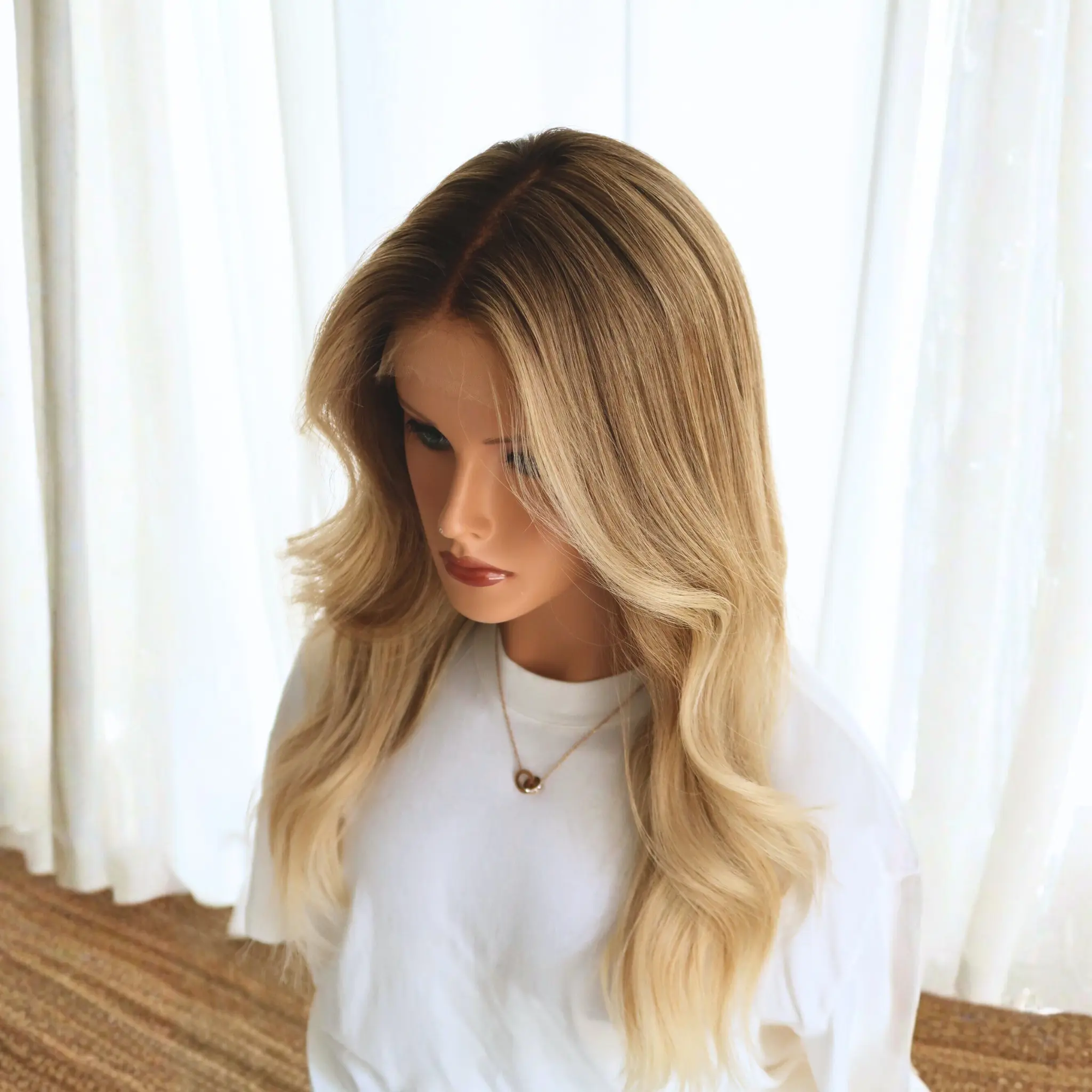 Detail view of glueless lace front edge and golden-toned strands on sunkissed honey blonde human hair wig with dark rooted