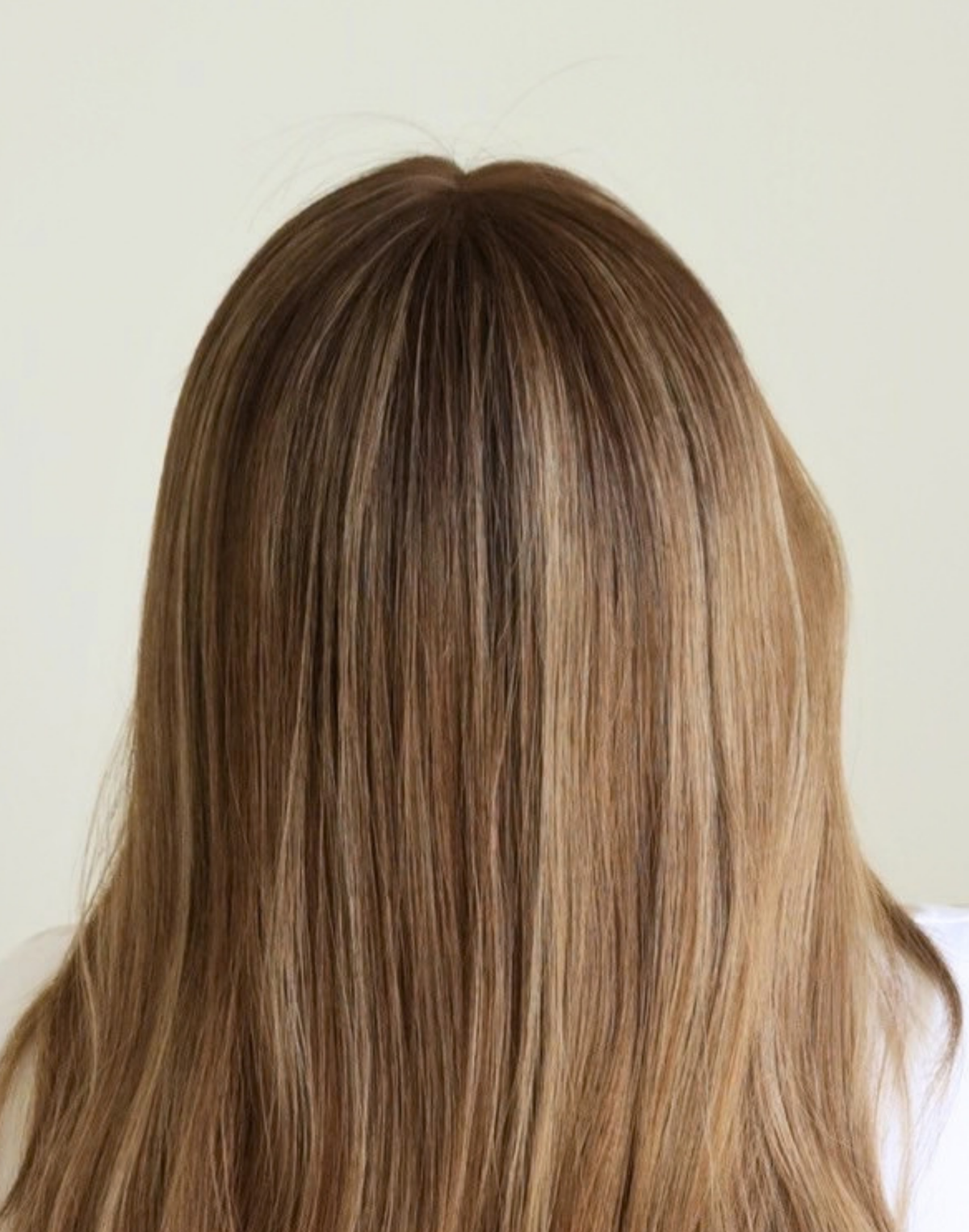 Detailed view of Amber 18-inch glueless brunette wig, showing the lace hairline, softly shaded roots, and natural-looking parting.